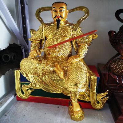 金色鎏金真武大帝銅像，單手持劍一腳盤坐一腳著地的真武祖師塑像
